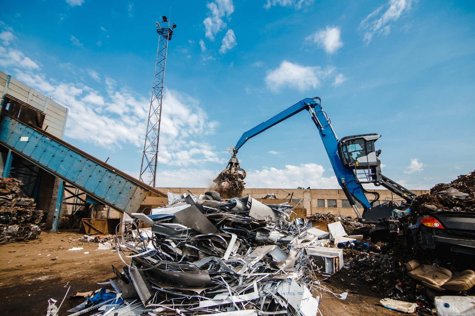 A claw crane grabbing the scrap at a rubbish dump